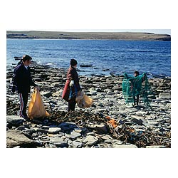 Bagging the Bruck - Women filling OIC plastic bags with beach waste one with net Bay of Skaill  photo 