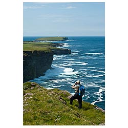 North coast - Seacliffs birdwatcher with binoculars watching bird watcher scotland cliff uk  photo 